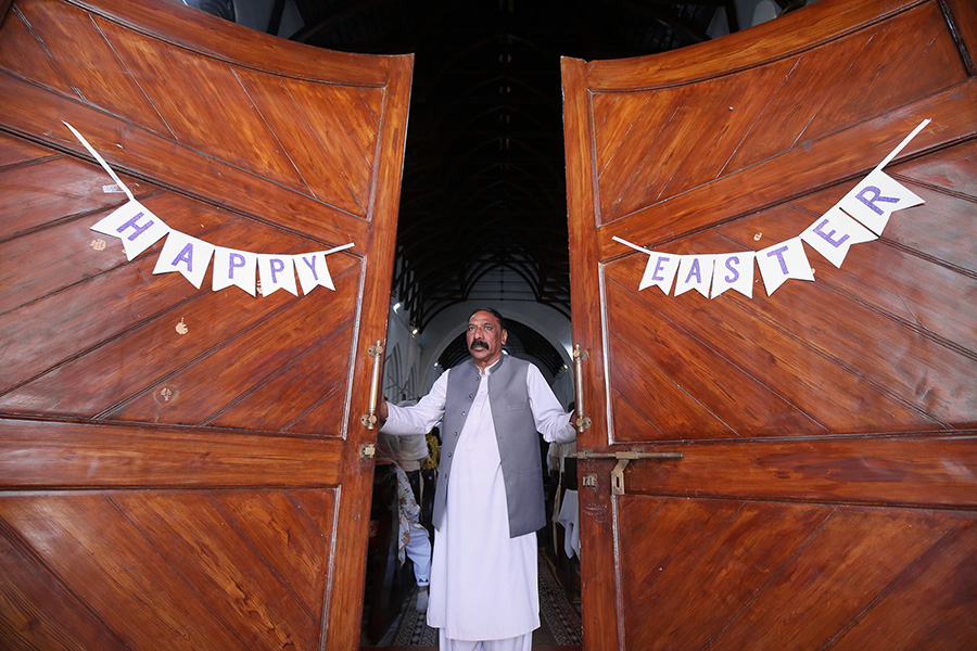 Член христианской общины у входа в соборную церковь Святого Иоанна в городе Пешавар на северо-западе Пакистана.