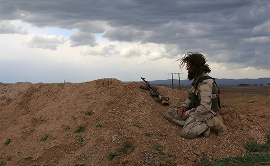 Сирийский повстанец осматривает окрестности с огневой точки