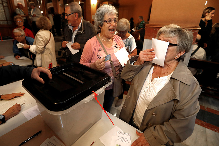 Женщина целует бюллетень перед тем, как опустить&nbsp;его в избирательную урну в Барселоне
&nbsp;
