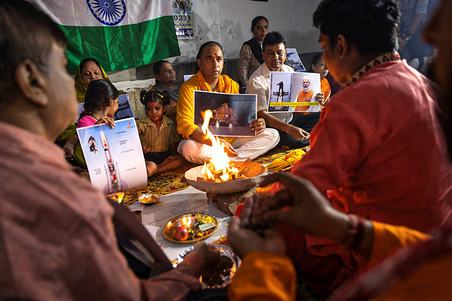 Люди в Нью-Дели 23 августа исполняют индуистский огненный ритуал хаван и молятся о благополучном прилунении миссии