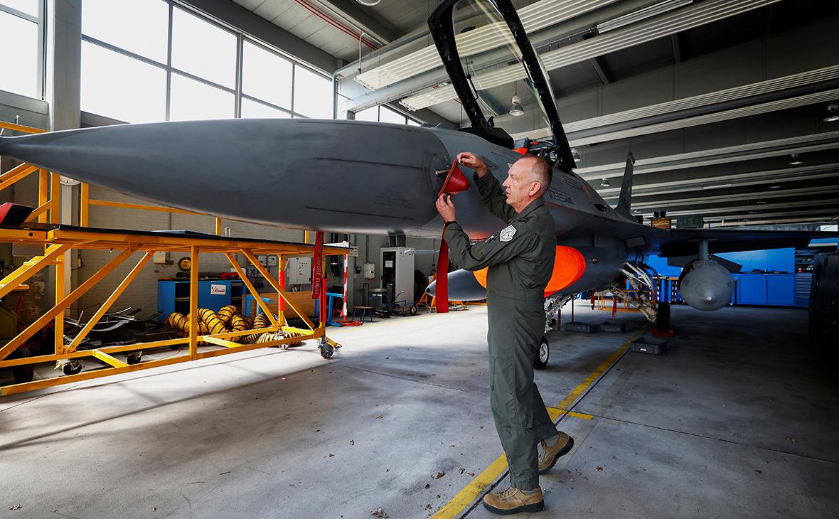 Голландский летчик, который будет помогать обучать украинских пилотов, демонстрирует истребитель F-16 в ангаре для техобслуживания в Волкеле, Нидерланды