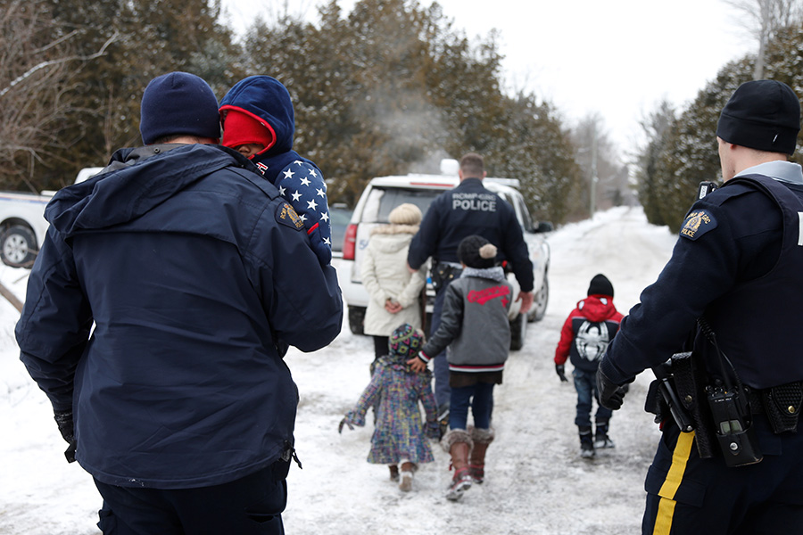 На фото: офицеры Королевской конной полиции провожают под стражу семью беженцев из Судана. До границы с Канадой они доехали на такси и попытались пересечь ее пешком. Для этого им пришлось пройти около километра по глубокому снегу.
