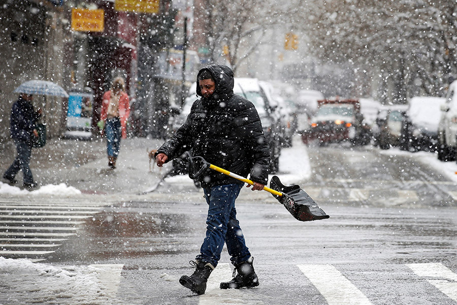 Мужчина с лопатой идет по нью-йоркскому району Чайнатаун