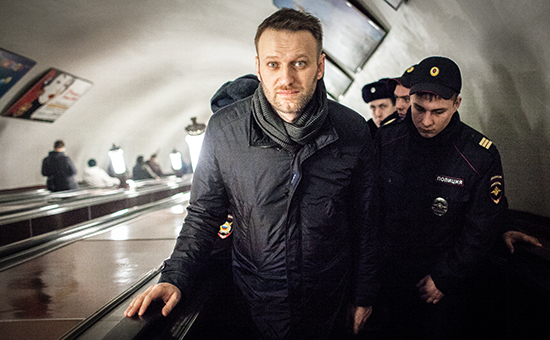 Оппозиционер Алексей Навальный (слева) и сотрудники полиции поднимаются по эскалатору на станции метро «Новослободская» во время задержания