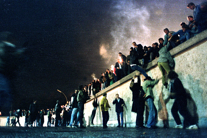 Граждане Восточной Германии перелезают через Берлинскую стену в ночь на 10 ноября. В течение трех последующих дней ФРГ посетили более 3 млн. человек.