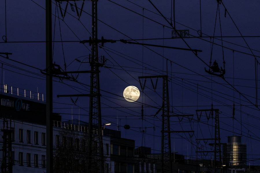 Полная луна восходит над центральным железнодорожным вокзалом в Нюрнберге, Германия, 05 ноября 2025 года