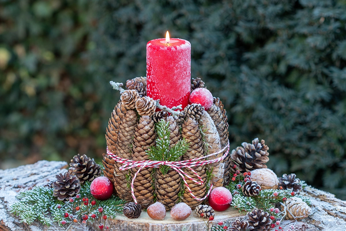 На фоне шишек будут хорошо смотреться красные, золотые или другие яркие свечи