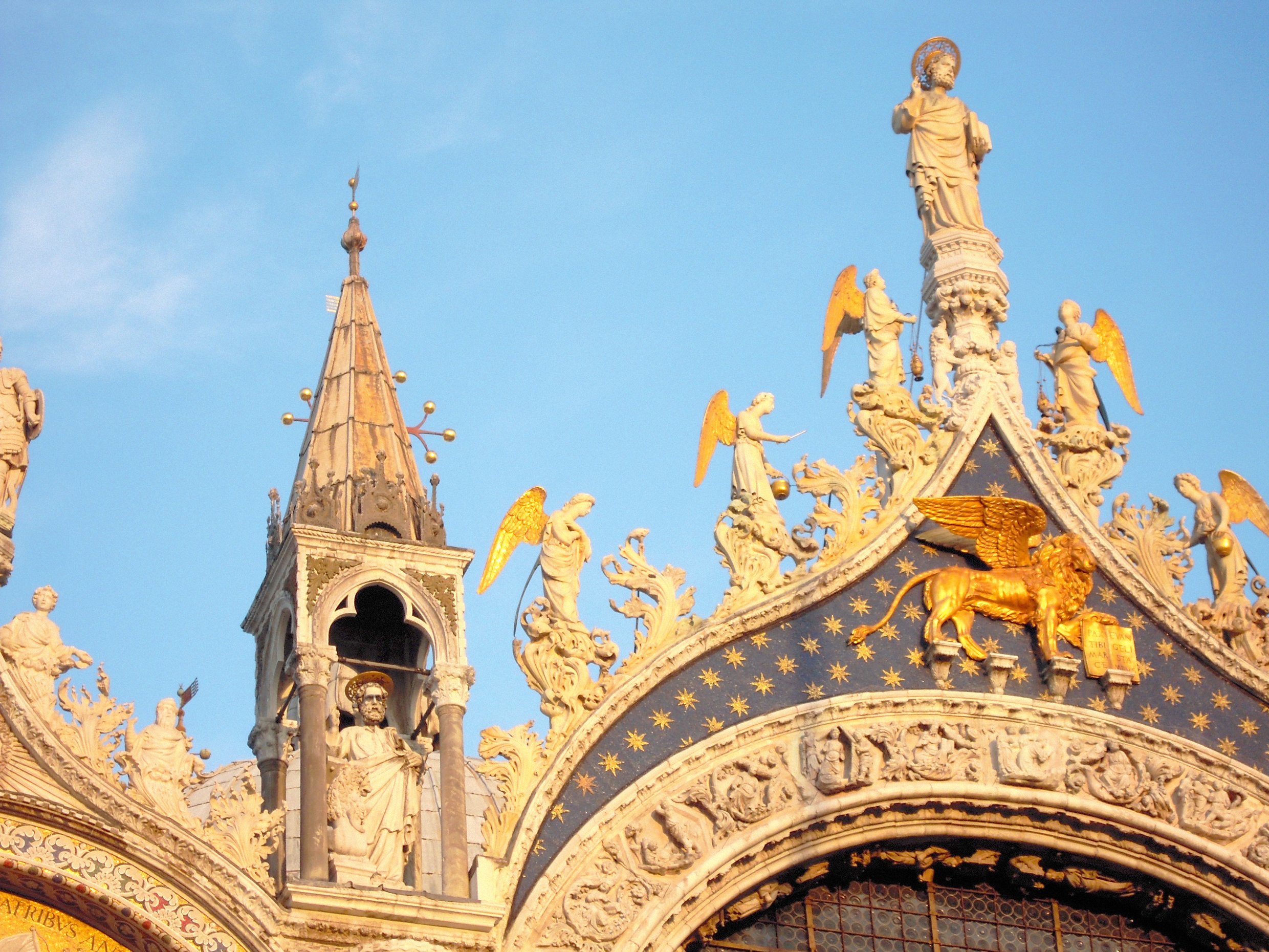 Отреставрированная скульптура крылатого льва Святого Марка и синяя мозаика с золотыми звездами на фасаде базилики Святого Марка в Венеции