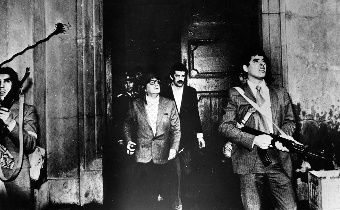 Президент Чили Сальвадор Альенде (в центре) покидает президентский дворец Ла&nbsp;Монеда&nbsp;11 сентября 1973 года, во время военного переворота, в ходе которого он был свергнут и убит

