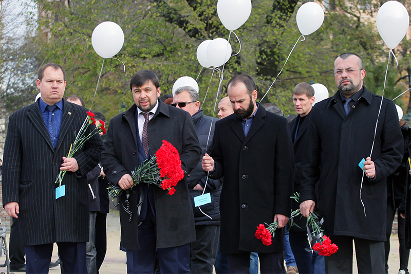 Заместитель председателя Народного совета ДНР Денис Пушилин (второй слева) возлагает цветы в память о погибших пассажирах