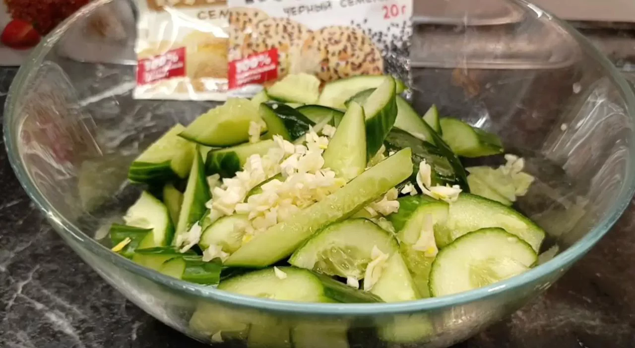 Положите чеснок в миску с огурцами