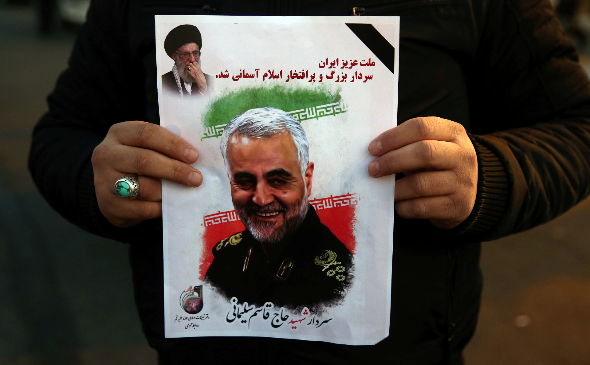 Мужчина держит фотографию убитого США генерал-майора Ирана Касема Сулеймани