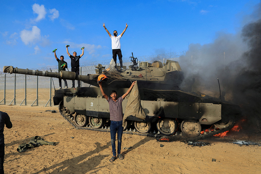 Палестинцы у горящего израильского танка после того, как по нему нанесли удар проникшие на юг&nbsp;Израиля силы ХАМАСа.