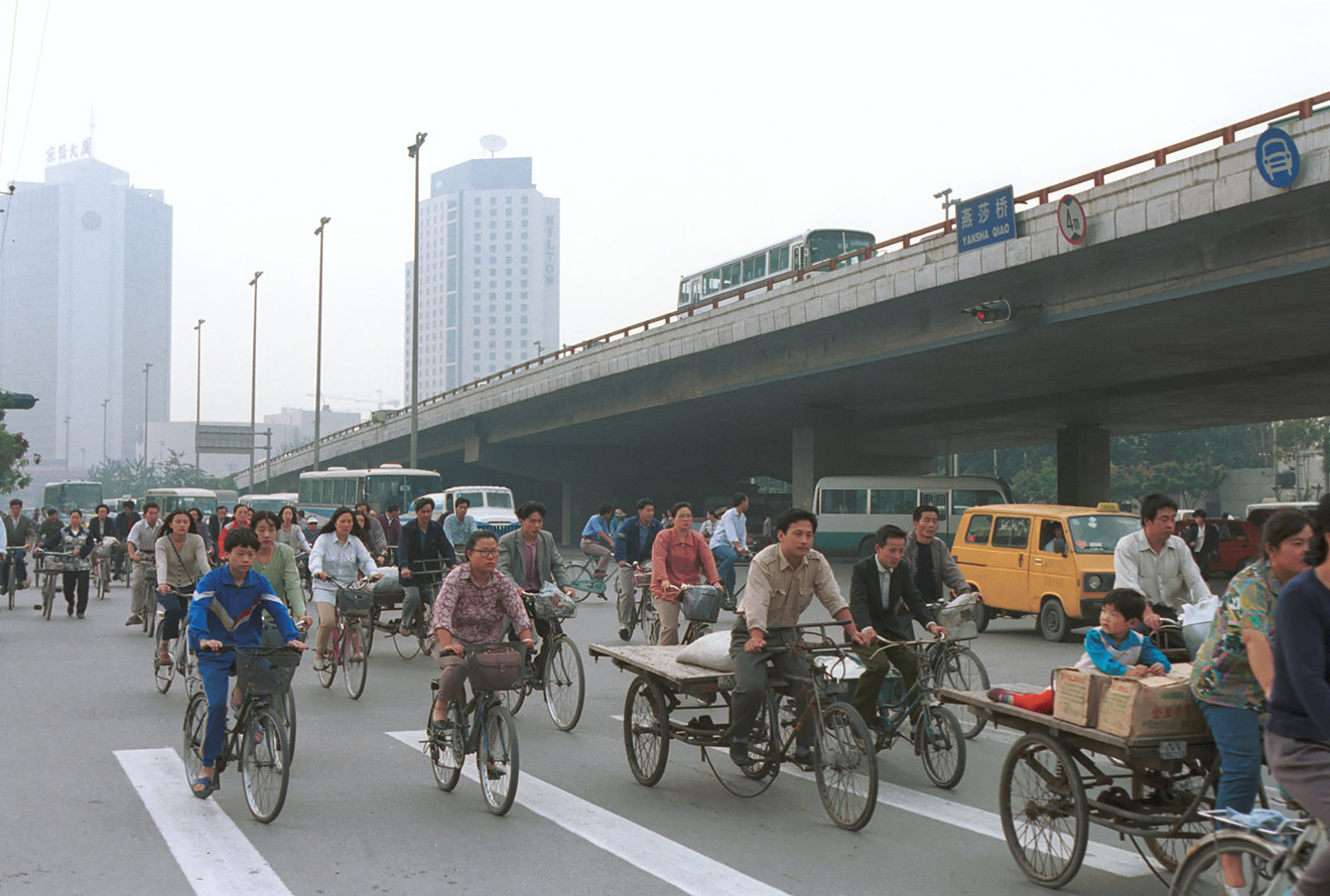 Пекин середины девяностых&nbsp;&mdash; все еще город велосипедов, но уже к концу десятилетия все резко изменится, и улицы заполонят автомобили.

