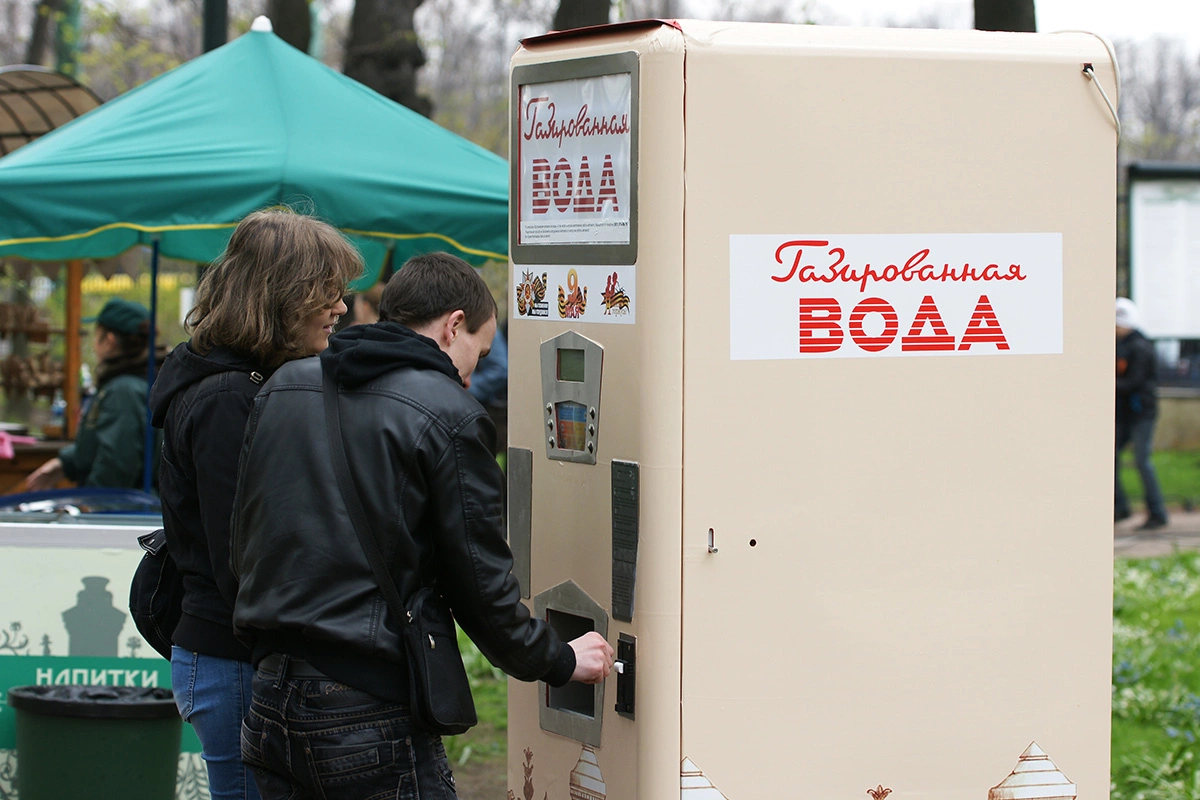 Люди покупают газированную воду в автомате в Санкт-Петербурге