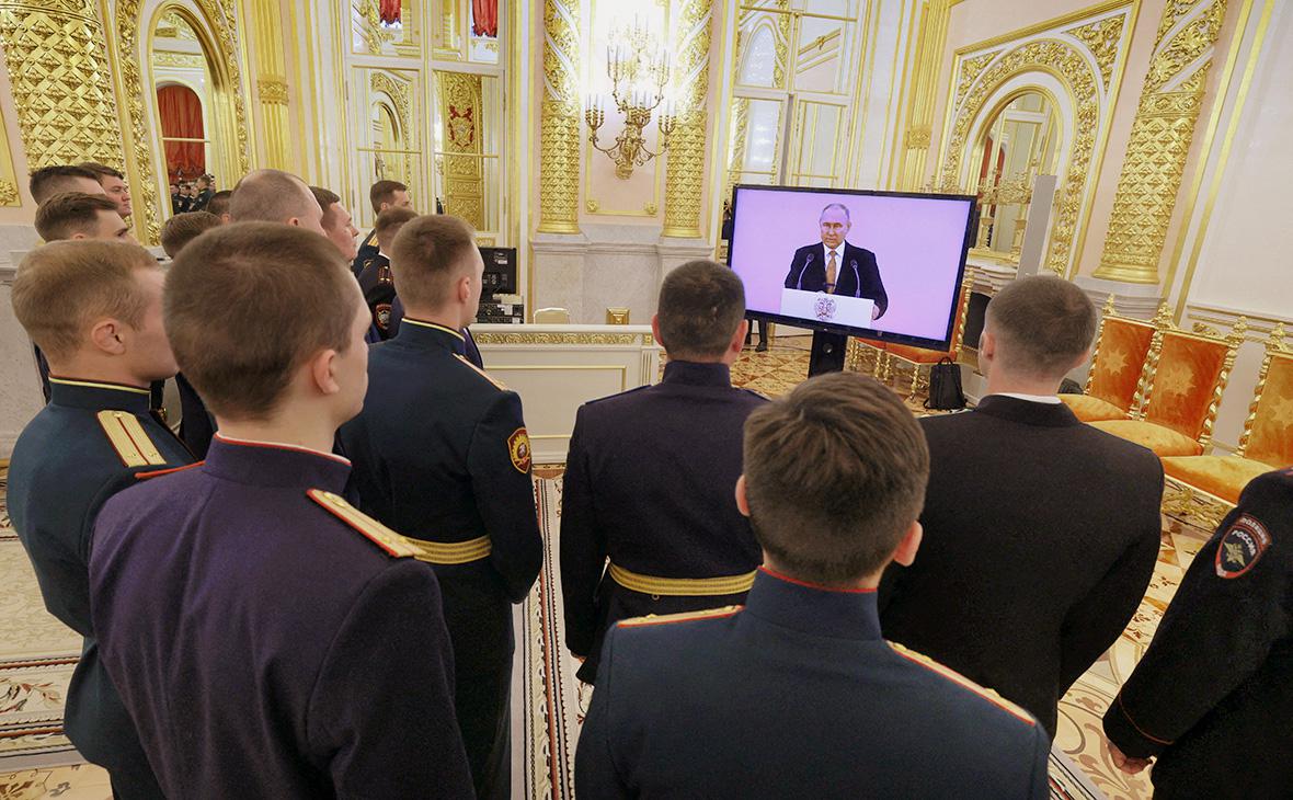 Выпускники военных вузов страны смотрят прямую трансляцию выступления Владимира Путина во время встречи в Кремле, Москва