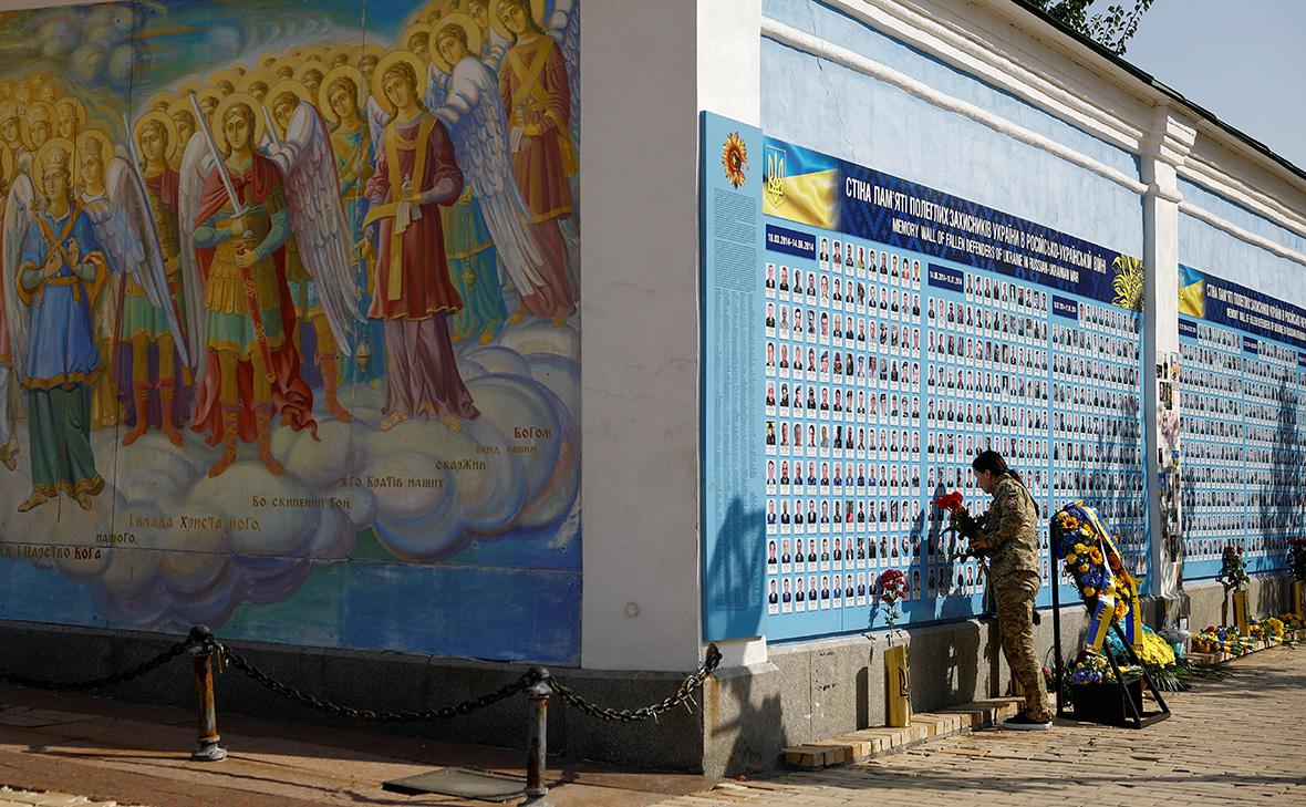 Украинская военнослужащая посещает Стену памяти павших за Украину во время празднования Дня защитников Украины, Киев, Украина, 1 октября 2024 года