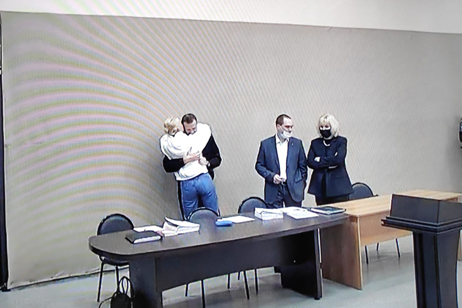 Алексей Навальный, Юлия Навальная и адвокат Ольга Михайлова (слева направо) на экране во время рассмотрения нового дела в отношении Алексея Навального