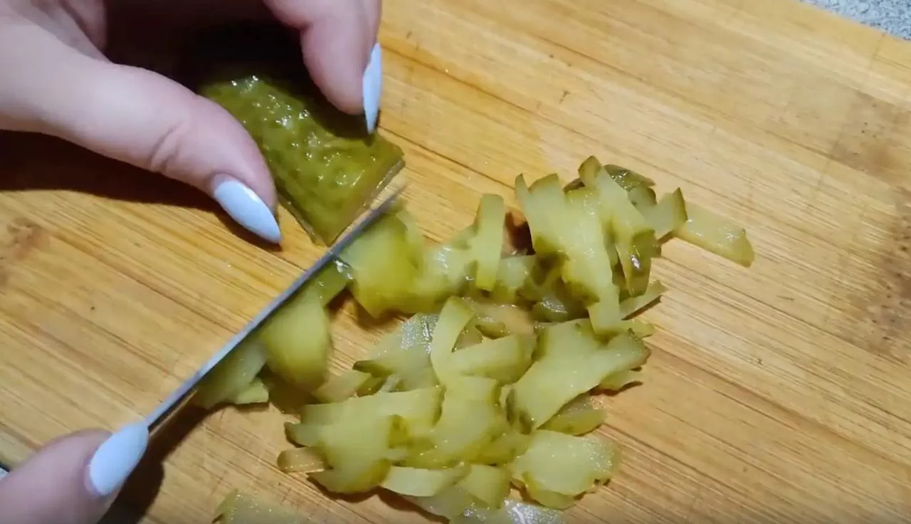 Мелко нарежьте маринованные огурцы