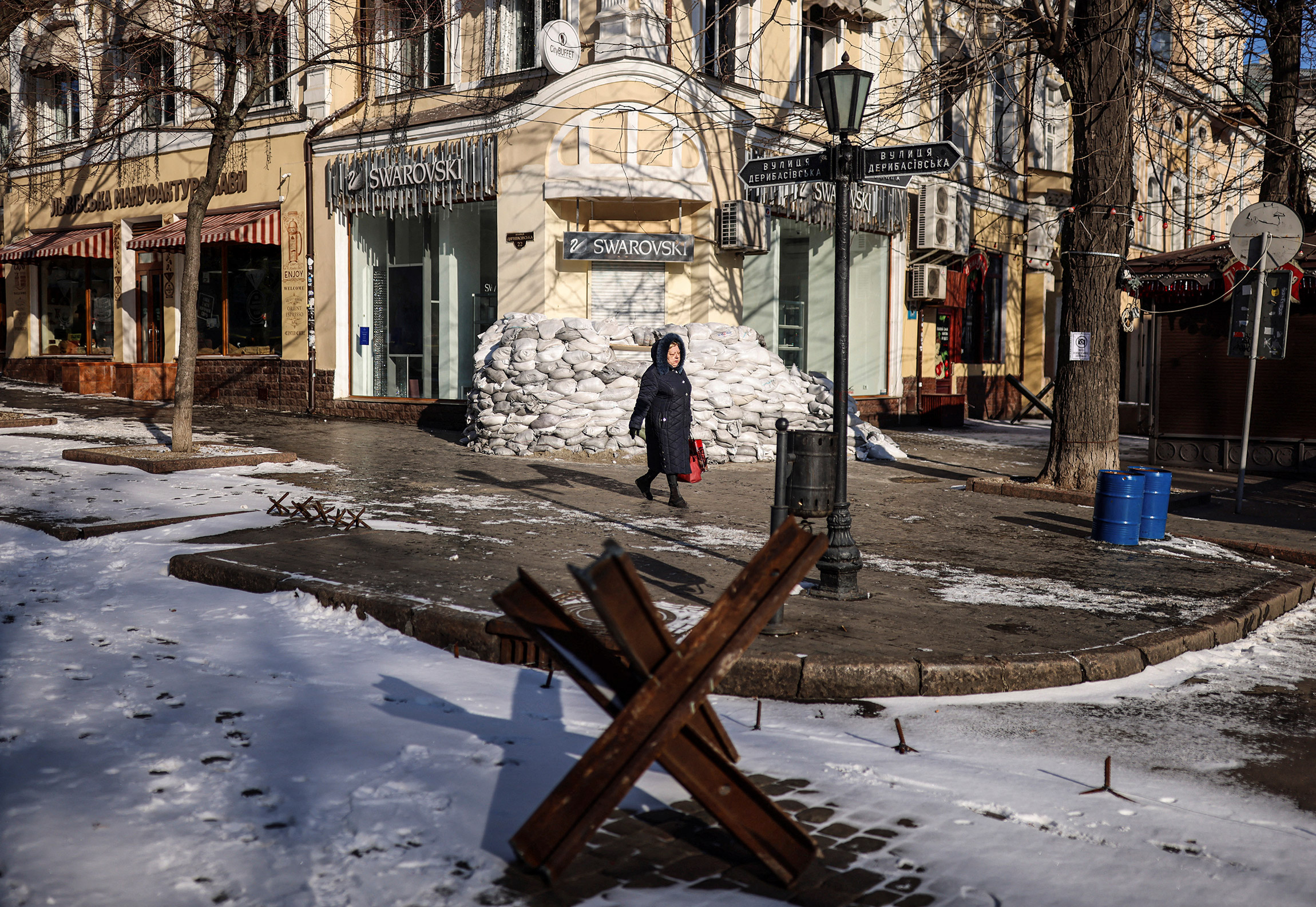Женщина направляется на работу мимо противотанковых ограждений, Одесса, Украина, 12 марта