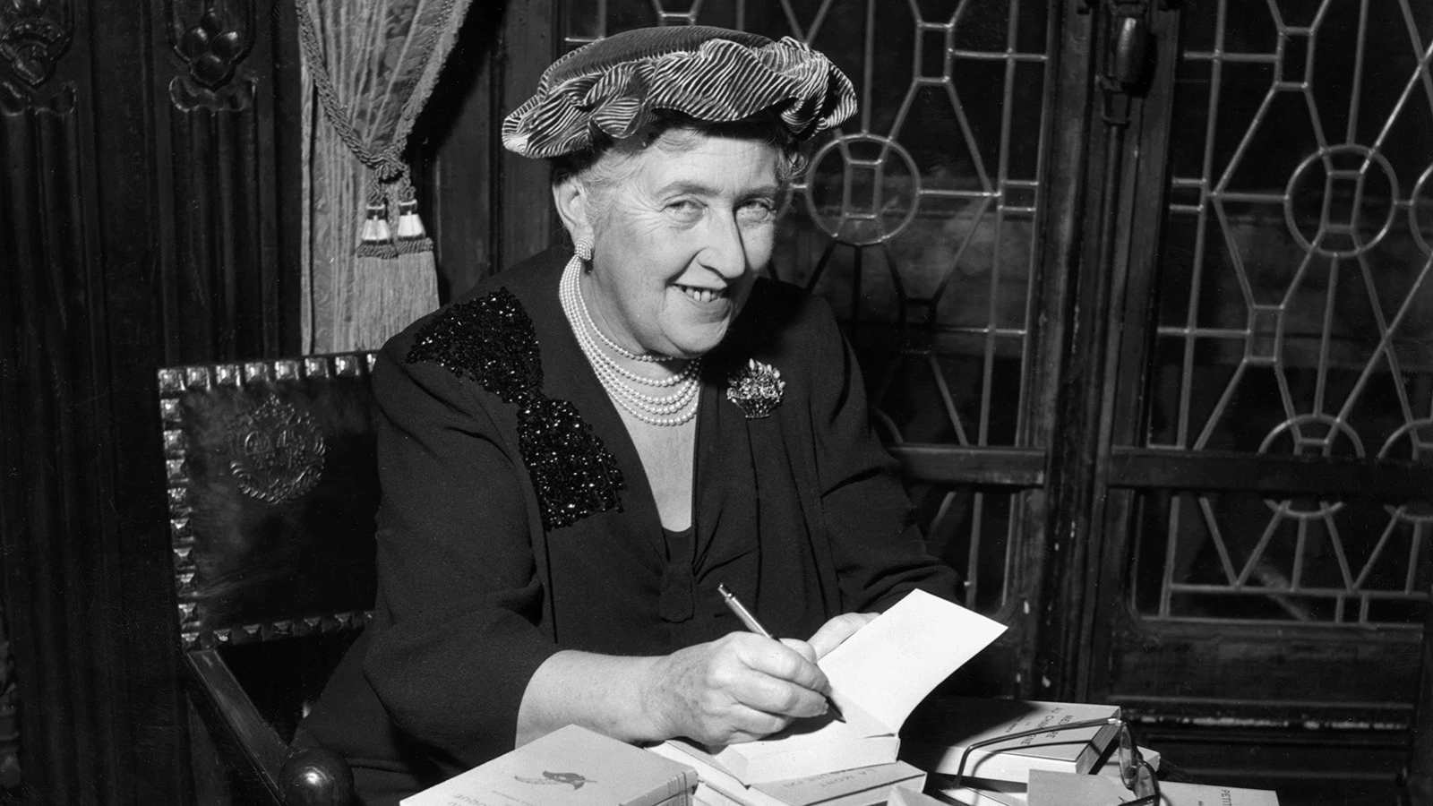 Агата Кристи оставляет автографы на французских изданиях своих книг, 1950 год