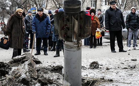 Люди у корпуса снаряда, упавшего в Краматорске