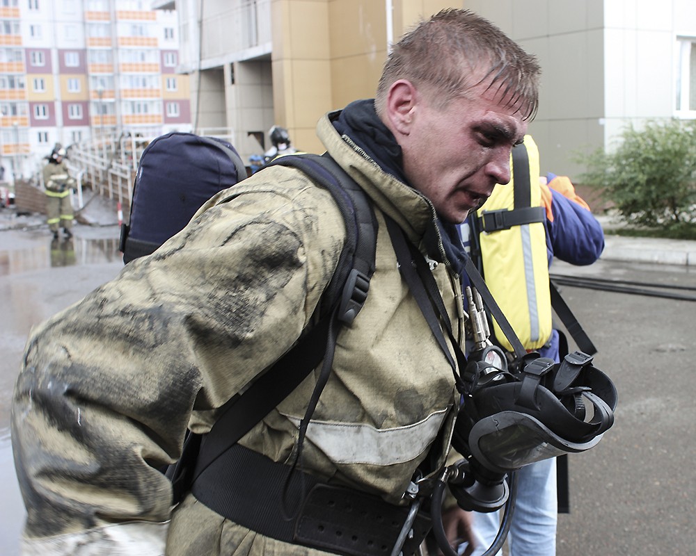 Пожарный во время тушения пожара в 25-этажном жилом доме в Красноярске 