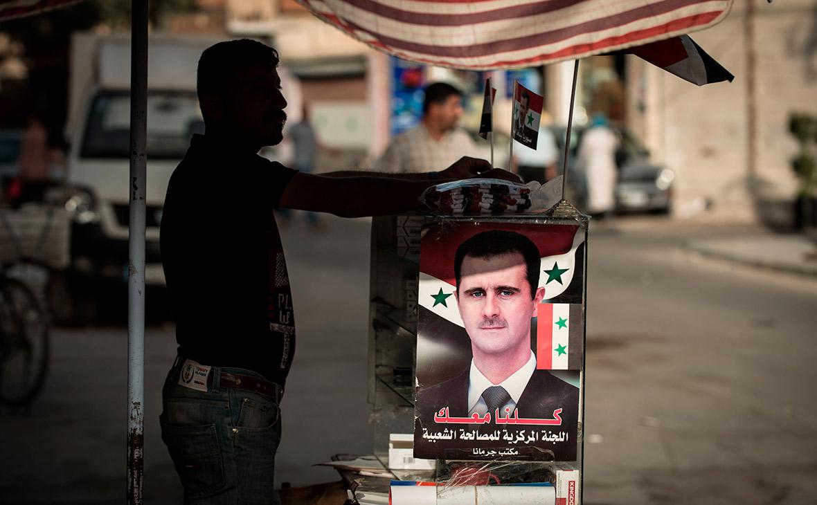 Плакатом с изображением Башара Асада