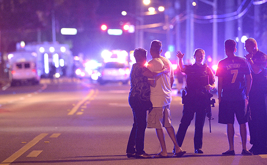 Сотрудники полиции и родственники посетителей ночного клуба в Орландо рядом с местом присшествия


