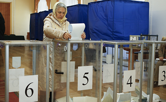 Проголосовавшая женщина опускает бюллетень в урну, Киев, 26 октября 2014г.