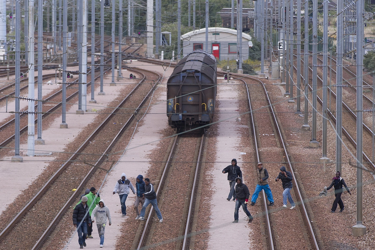 <p>Мигранты, пытающиеся проникнуть через Евротоннель в Великобританию</p>