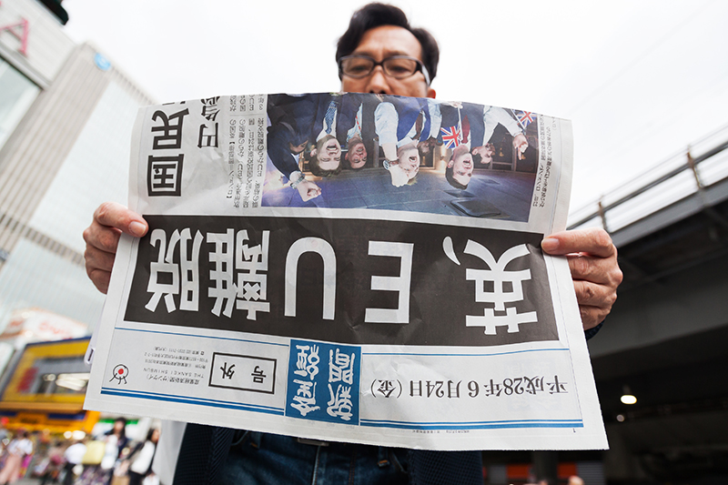 Мужчина читает специальный выпуск японской газеты, в&nbsp;котором говорится об&nbsp;итогах голосования в&nbsp;Великобритании