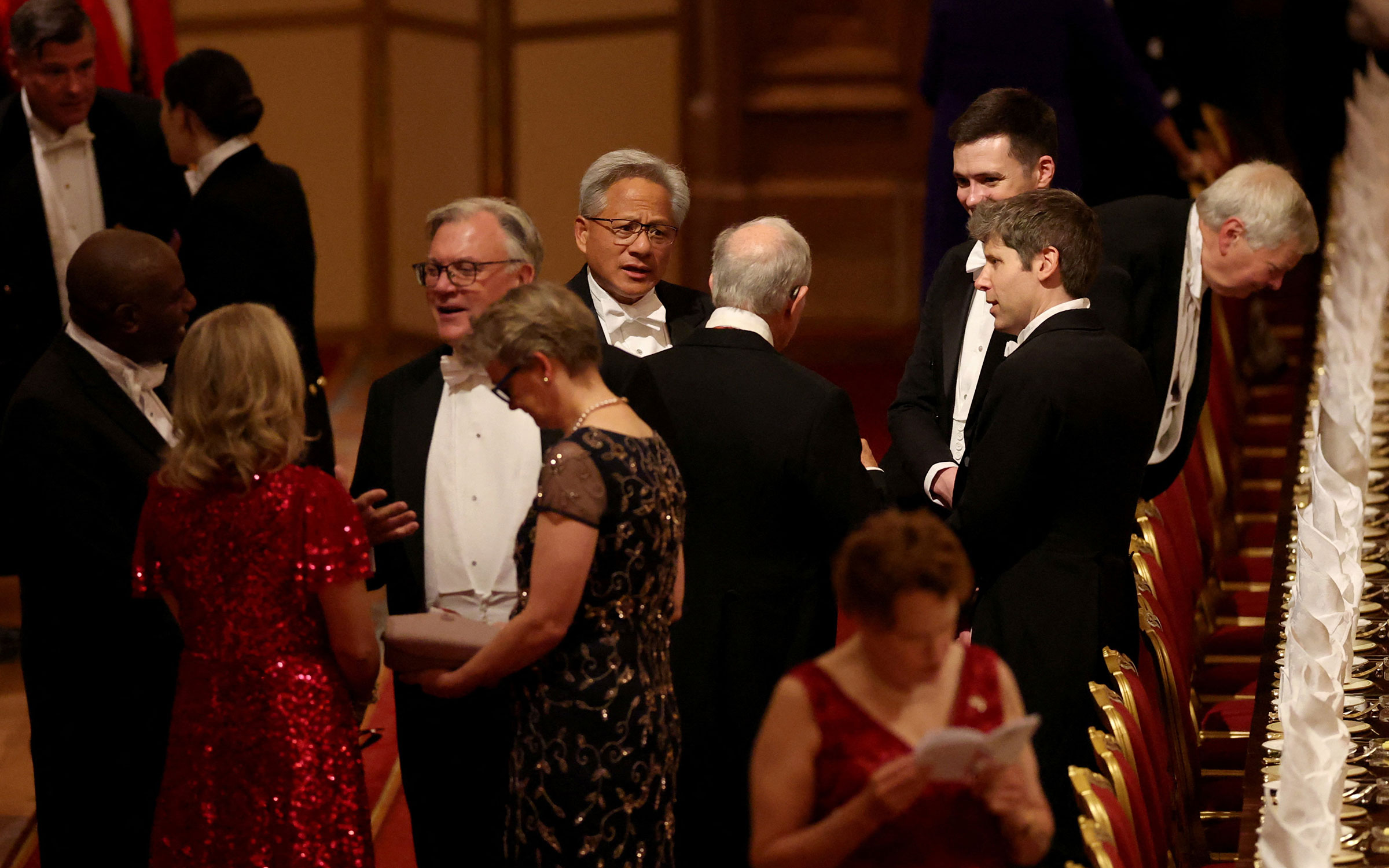 В числе гостей были гендиректор OpenAI Сэм Альтман (крайний справа) и CEO Nvidia Дженсен Хуанг (в центре). Незадолго до государственного визита страны согласовали инвестиции американских IT-гигантов в британскую экономику на сумму $42 млрд. Проекты будут направлены на развитие ИИ, атомной энергетики&nbsp;и квантовых компьютеров.