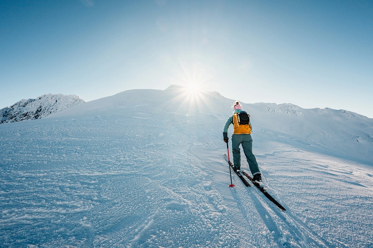 Ски-альпинист поднимается в гору