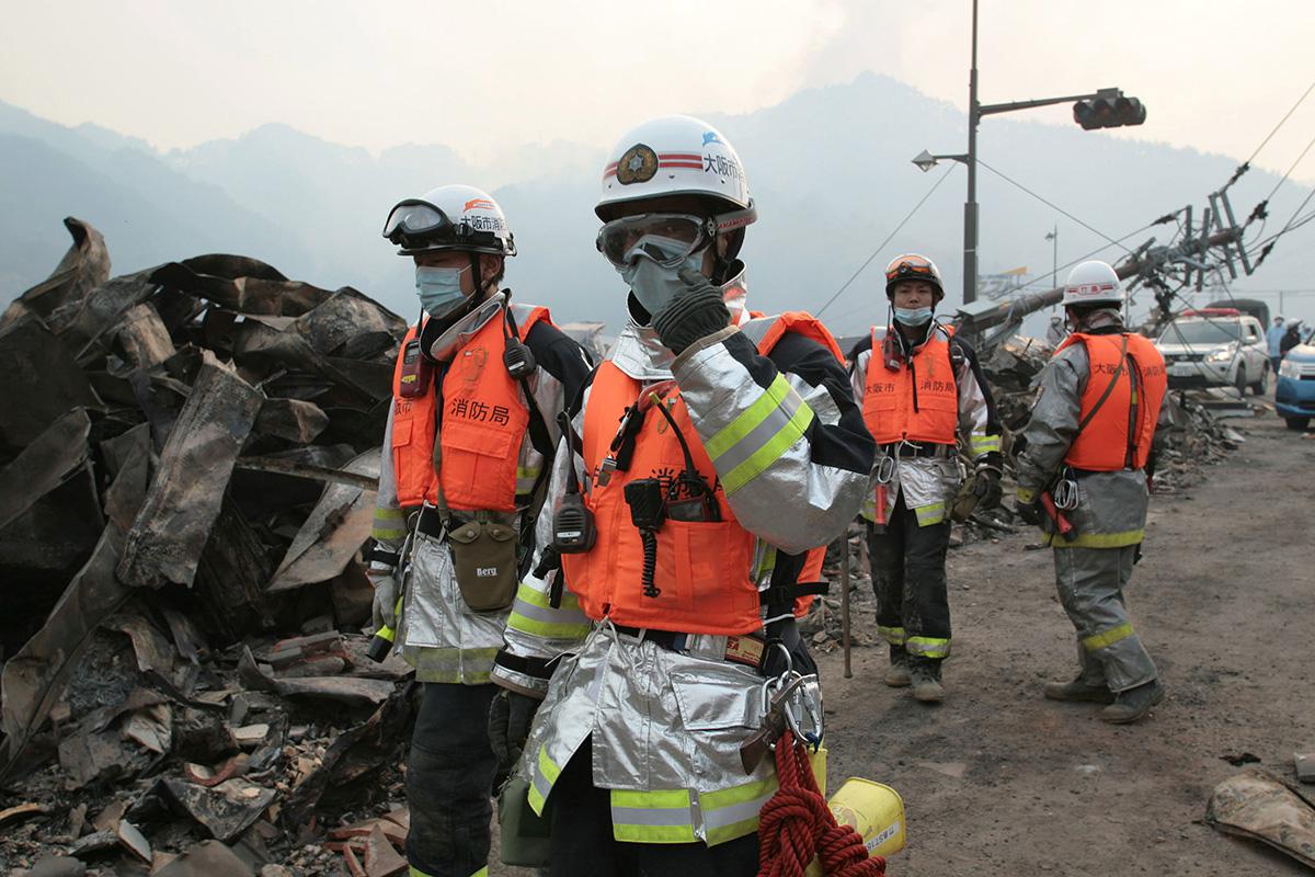 Пожарные ведут поисково-спасательные работы после цунами, город Оцути, Япония, 11 марта 2011 года