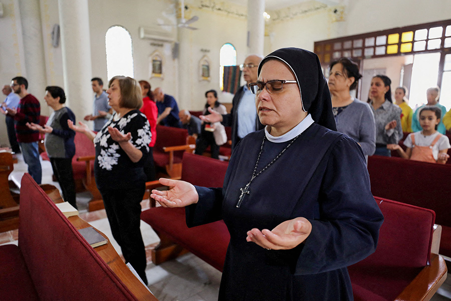 Монахиня молится во время пасхальной службы&nbsp;в церкви Святого Семейства в секторе Газа.
