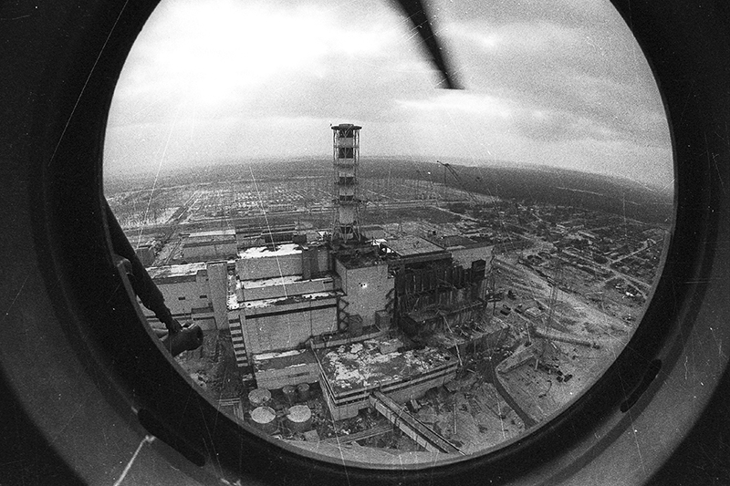 В первые дни после&nbsp;аварии в&nbsp;Чернобыль были направлены два фотокорреспондента ТАСС&nbsp;&mdash;&nbsp;сотрудник московской редакции Валерий Зуфаров и&nbsp;фотожурналист киевского филиала Владимир Репик. Кроме&nbsp;них&nbsp;последствия аварии освещали фоторепортер АПН (ныне &laquo;РИА Новости&raquo;) Игорь Костин и&nbsp;штатный фотограф ЧАЭС Анатолий Рассказов.

На этом фото через&nbsp;иллюминатор вертолета Репик запечатлел возведение саркофага над&nbsp;разрушенным четвертым энергоблоком ЧАЭС.​ Защитную конструкцию воздвигали в&nbsp;течение&nbsp;полугода, завершив постройку к&nbsp;ноябрю 1986 года.
