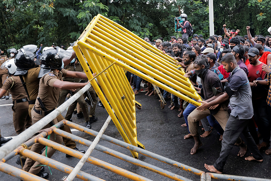 На фото: демонстранты сносят металлические ограждения, пытаясь добраться до здания парламента. Коломбо, 8 апреля