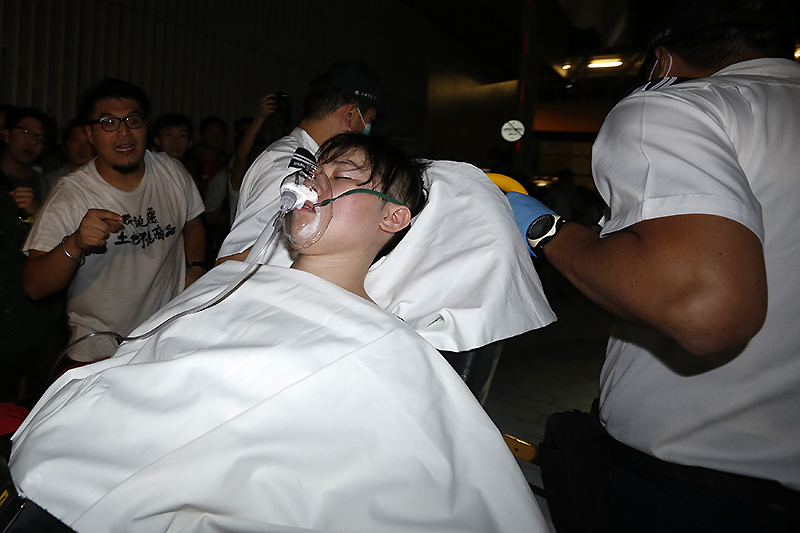 Спасатели уносят демонстранта, получившего травмы во время штурма штаб-квартиры правительства.