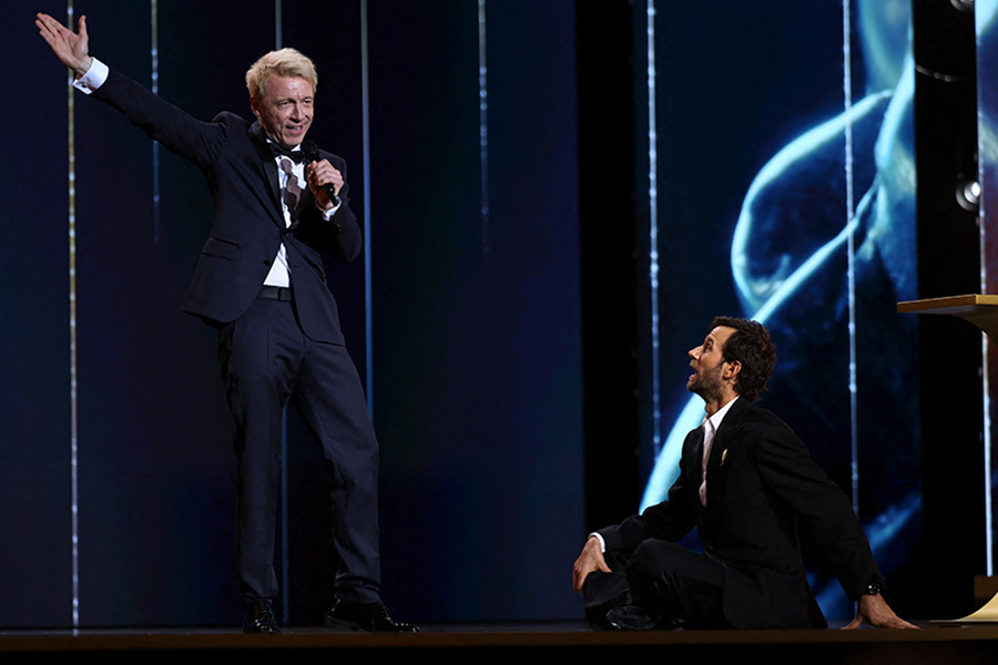 На фото: ведущий церемонии Бенжамен Лаверн и актёр дубляжа Эмманюэль Кюртиль. Последний, пользуясь случаем, призвал министра культуры защитить права актёров при использовании ИИ.  На премии «Сезар» почтили память Брижит Бардо, ушедшей в декабре 2025 года в возрасте 91 года. После показа нарезки из фильмов с её участием кто-то из зрителей выкрикнул «Расистка!» &mdash; актриса была пять раз осуждена за подобные высказывания.