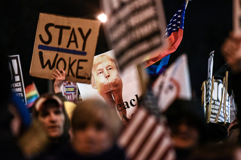 Люди держат плакаты с лозунгами против избранного президента США&nbsp;Дональда Трампа
