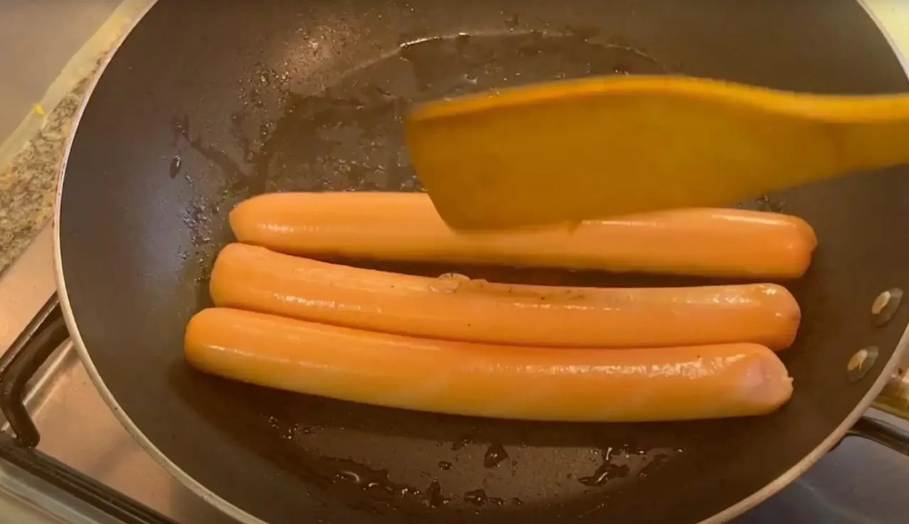 Положите сосиски на сковороду