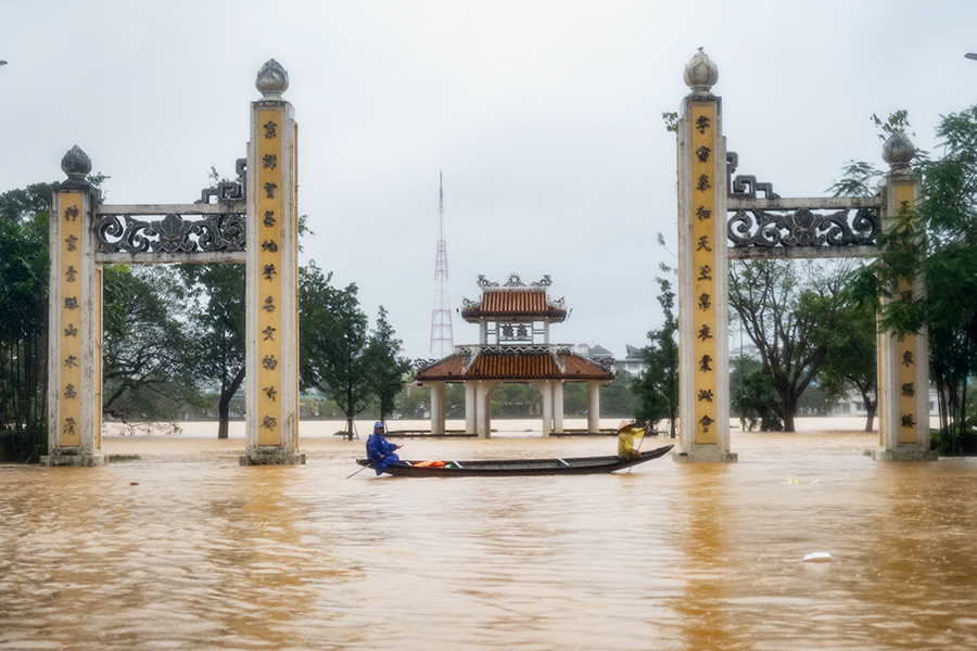 Местные жители плывут на лодке по затопленной площади в Хюэ