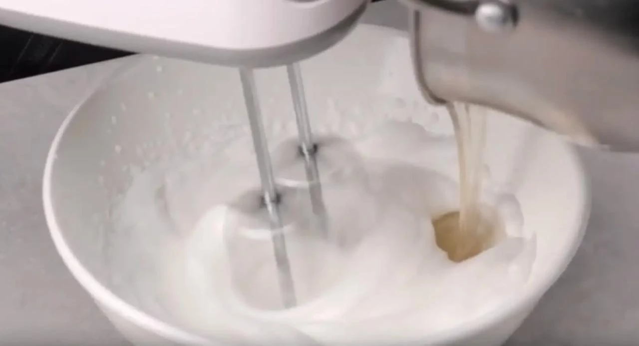 Влейте сироп во взбитые белки