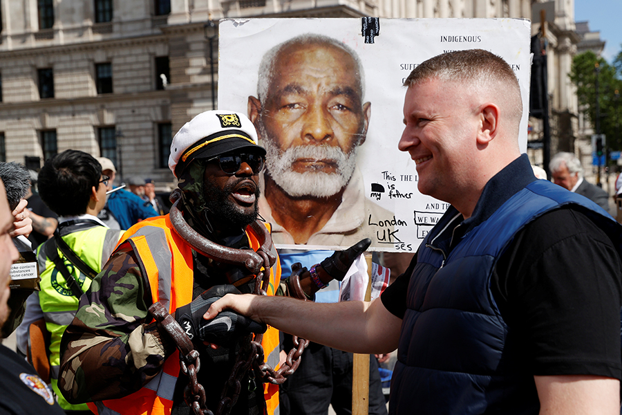 Демонстрант жмет руку лидеру ультраправой группировки &laquo;Британия в первую очередь&raquo; Полу Голдингу​ в Лондоне
