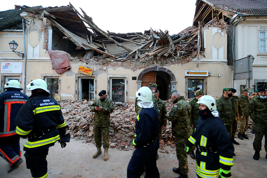Солдаты и спасатели перед разрушенным в результате землетрясения зданием
&nbsp;