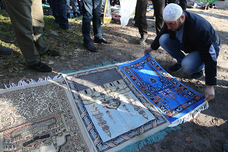 Мусульманин расстилает ковер для молитвы на празднике Курбан-Байрам у мечети на улице Аллея смелых в городе Калининград.