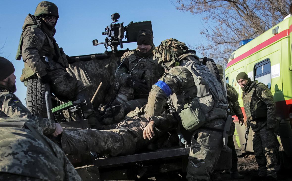 Украинские военнослужащие эвакуируют раненых во время обстрела на передовой, недалеко от Бахмута