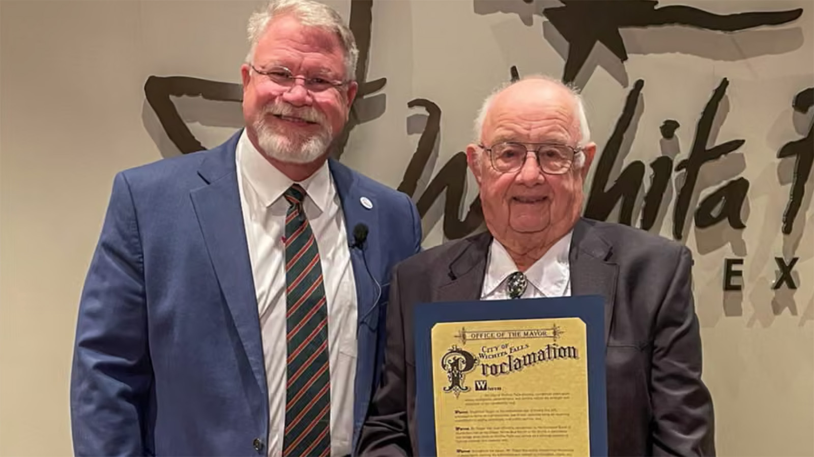 Рэймонд Хейгер (справа) получает награду от мэра Уичито-Фолс Тима Шорта на заседании городского совета 18 ноября