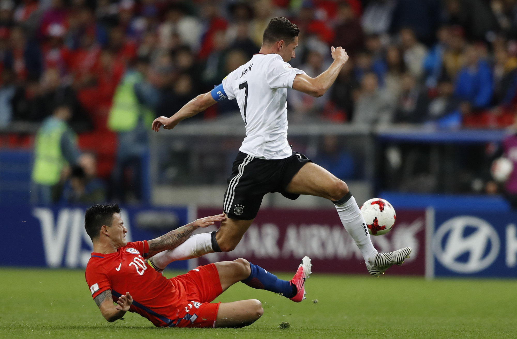 Чилийский полузащитник Чарльз Арангис (слева) пытается отобрать мяч у капитана сборной Германии Юлиана Дракслера
